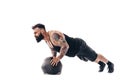 Muscular tattooed bearded male exercising fitness weights Medicine Ball push ups exercises in studio isolated on white Royalty Free Stock Photo