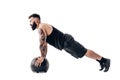 Muscular tattooed bearded male exercising fitness weights Medicine Ball push ups exercises in studio isolated on white Royalty Free Stock Photo