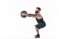 Muscular tattooed bearded male exercising fitness weights Medicine Ball in studio isolated on white background Royalty Free Stock Photo