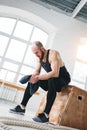 Muscular tired man resting on box and hold towel in hand