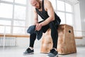 Muscular tired man resting on box and hold towel in hand