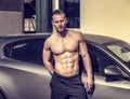 Muscular topless man outside of car