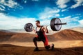 Muscular weightlifter doing squats with a barbell