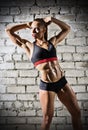 Muscular woman on brick wall background (dark version) Royalty Free Stock Photo
