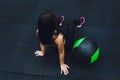 Muscular woman doing intense core workout in gym. Strong female doing core exercise on fitness mat with medicine ball in Royalty Free Stock Photo