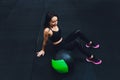 Muscular woman doing intense core workout in gym. Strong female doing core exercise on fitness mat with medicine ball in Royalty Free Stock Photo