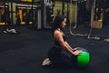 Muscular woman doing intense core workout in gym. Strong female doing core exercise on fitness mat with medicine ball in Royalty Free Stock Photo