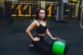 Muscular woman doing intense core workout in gym. Strong female doing core exercise on fitness mat with medicine ball in Royalty Free Stock Photo