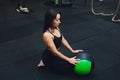 Muscular woman doing intense core workout in gym. Strong female doing core exercise on fitness mat with medicine ball in Royalty Free Stock Photo