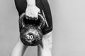 Muscular woman holding old and rusty kettle bell in her hand