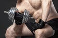 Muscular yong man exercising with dumbbell Royalty Free Stock Photo