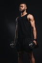 muscular young african american man holding dumbbells and looking away Royalty Free Stock Photo