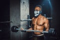 Muscular young african american man in mask lifting barbell on biceps. Exercise for biceps with barbell. black man in gym Royalty Free Stock Photo