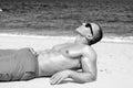 Muscular young athletic man lying on the beach Royalty Free Stock Photo