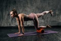 Muscular young athletic woman with perfect beautiful body wearing sportswear exercising buttocks legs using foam roller Royalty Free Stock Photo