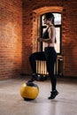 Muscular young athletic woman with strong beautiful body in sportswear exercising with heavy medicine ball during Royalty Free Stock Photo