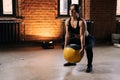 Muscular young athletic woman with strong beautiful body wearing sportswear exercising with heavy medicine ball during Royalty Free Stock Photo