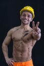 Muscular young construction worker shirtless doing peace sign Royalty Free Stock Photo