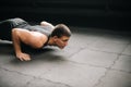 Muscular young man with beautiful body and naked torso doing push-ups exercise. Royalty Free Stock Photo