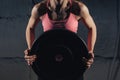 Muscular young fitness woman lifting a weight crossfit in the gym. Fitness woman deadlift barbell. The gym on the red Royalty Free Stock Photo