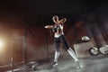 Muscular young fitness woman lifting a weight in the gym