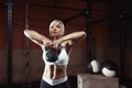 Muscular young fitness woman lifting a weight in the gym