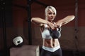 Muscular young fitness woman lifting a weight in the gym