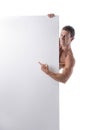 Muscular young man behind a blank vertical white banner