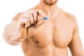 Muscular young man holding blue pill Royalty Free Stock Photo