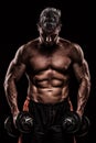 Muscular young man lifting weights on dark background Royalty Free Stock Photo