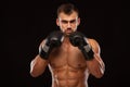 Muscular young man with perfect Torso with six pack abs, in boxing gloves is showing the different movements and strikes Royalty Free Stock Photo