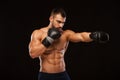 Muscular young man with perfect Torso with six pack abs, in boxing gloves is showing the different movements and strikes Royalty Free Stock Photo