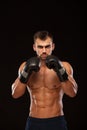 Muscular young man with perfect Torso with six pack abs, in boxing gloves is showing the different movements and strikes Royalty Free Stock Photo