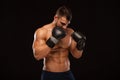 Muscular young man with perfect Torso with six pack abs, in boxing gloves is showing the different movements and strikes Royalty Free Stock Photo