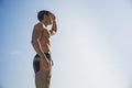 Muscular young man shirtless against the sky Royalty Free Stock Photo