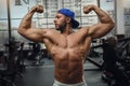 Muscular young man shows his muscles in the gym. Royalty Free Stock Photo