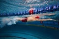 Muscular young man, swimmer in motion, preparing for competition, training in swimming pool indoors. Speed and technique Royalty Free Stock Photo