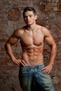 Muscular young naked man posing in blue jeans