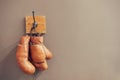 Museum of box sport. Box exhibition retro attributes. Boxing school. Vintage boxing gloves hang on hook wall background