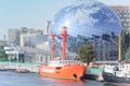 Museum complex of World Ocean in mock-up glass ball, Earth globe. Floating lighthouse on pier