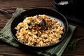 Mushroom barley risotto or orzotto in a black plate. Made with pioppini and porcini mushrooms.