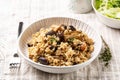 Mushroom barley risotto or orzotto in a white plate on a line tablecloth.