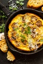 Mushroom frittata with parmesan cheese and fresh parsley in pan