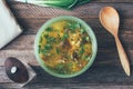 Mushroom soup in the dish, the green onions, the wooden spoon, and a pepper mill on the old wooden table Royalty Free Stock Photo