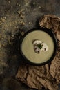 Mushroom soup with 3 mushrooms on top on rusty brown background and wrinkled texture