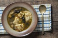 Mushroom soup plate with porcini mushrooms, dumplings, potato, carrot, onion, fresh green dill and pepper on black background, Royalty Free Stock Photo