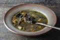 Mushroom soup plate with porcini mushrooms, potato, carrot, onion, fresh green dill and pepper on black background, closeup Royalty Free Stock Photo