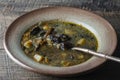 Mushroom soup plate with porcini mushrooms, potato, carrot, onion, fresh green dill and pepper on black background, closeup Royalty Free Stock Photo