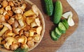 mushrooms chanterelles in a basket cucumbers on the table on wooden background