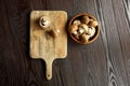 Mushrooms on cutting board, fresh brown champignons in bowl on a wooden background, top view. Uncooked food ingredient, flat lay